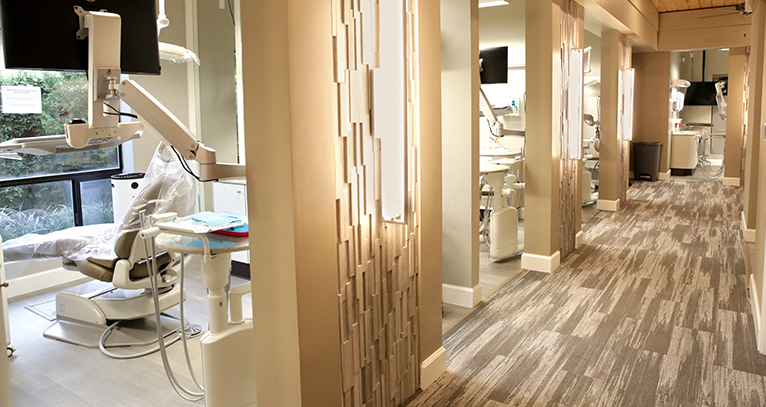 An angled photo peering into our patient rooms shows chairs and dental equipment.