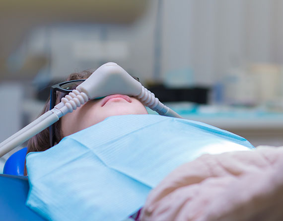 A little boy has a tube over his nose providing inhalable nitrous oxide