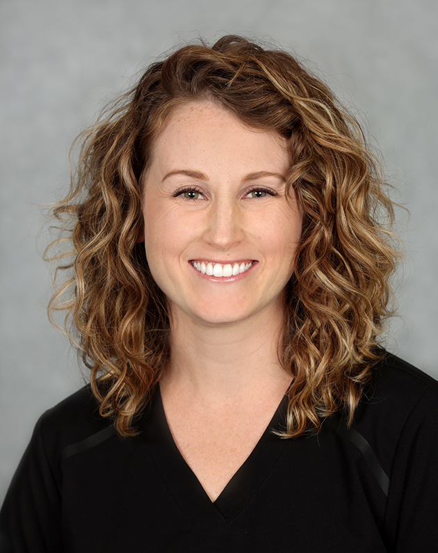 A headshot of Katelyn who has shoulder length curly hair.