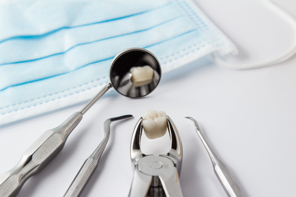 dental instruments displayed on a clinical tray with an extracted tooth, representing tooth removal as a treatment option when a tooth cannot be saved.