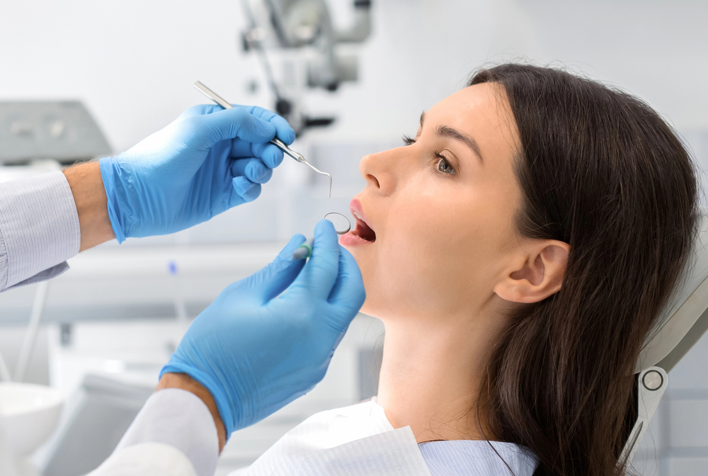 Dentist performing a root canal procedure on a female patient in a modern dental office.