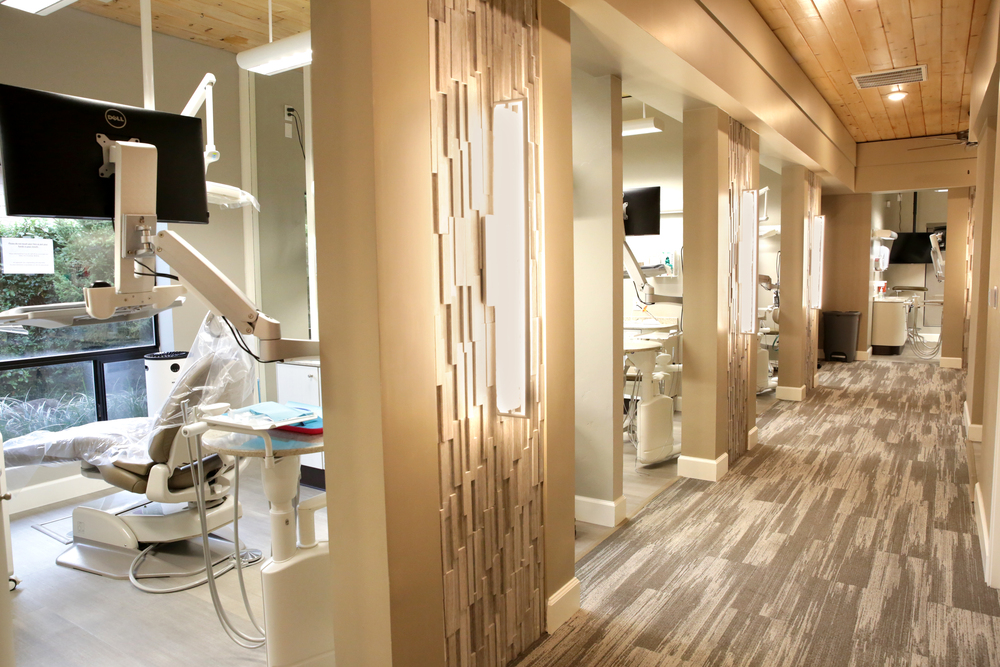 Clean and modern dental office hallway with treatment rooms, reflecting the importance of a comfortable environment when selecting a dentist.
