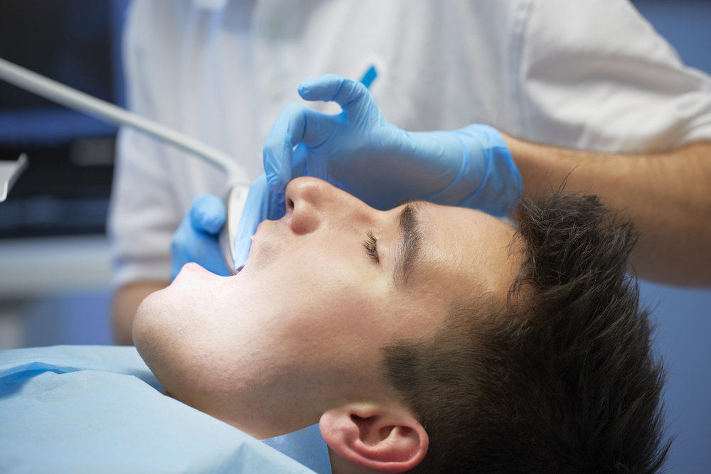 man in dental chair representing how long does a root canal take