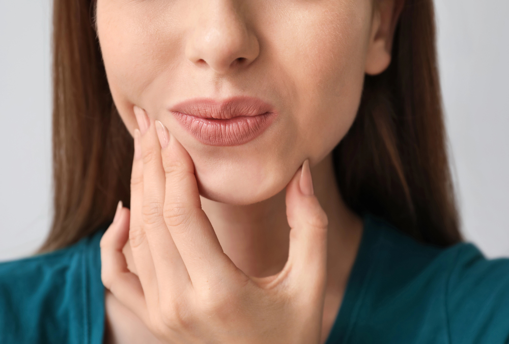 person holding jaw in pain indicating tooth sensitivity
