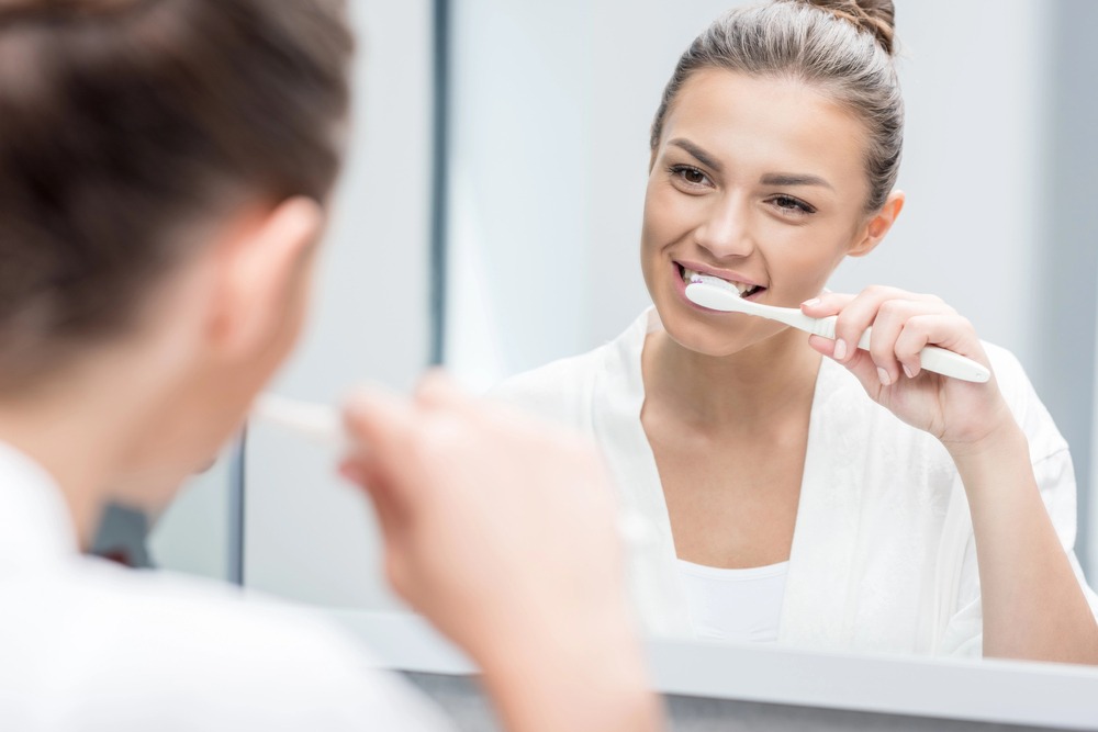 woman brushing teeth as a method on how to strengthen teeth